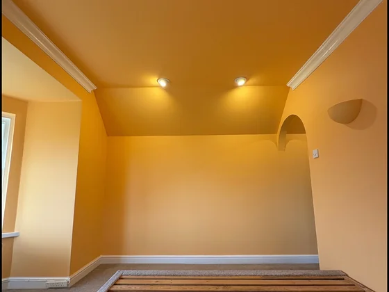 Bold interior refurbishment with striking warm orange walls and recessed lighting by Goulds D&F