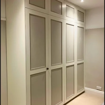 Hallway with large fitted wardrobes freshly painted in cream with panel door detailing